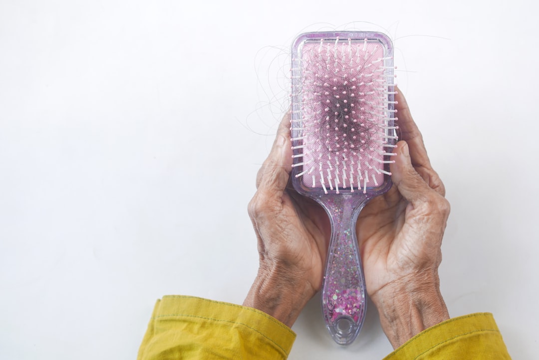 Hairbrush with fallen hair strands showing hair loss