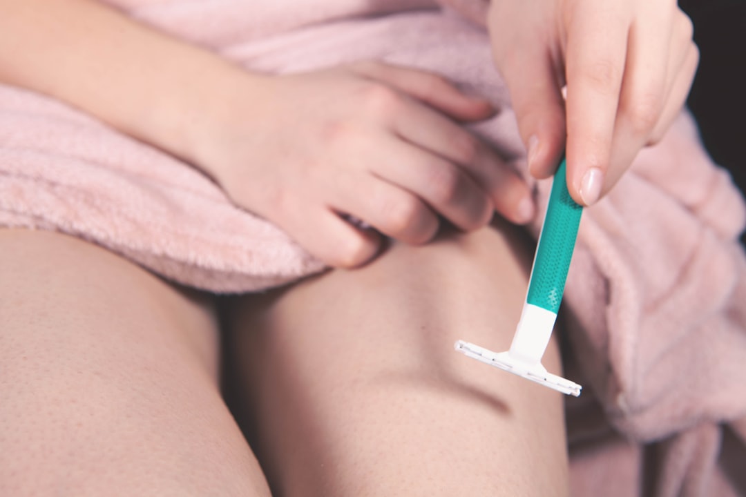 Woman removing unwanted leg hair as part of a hair removal routine