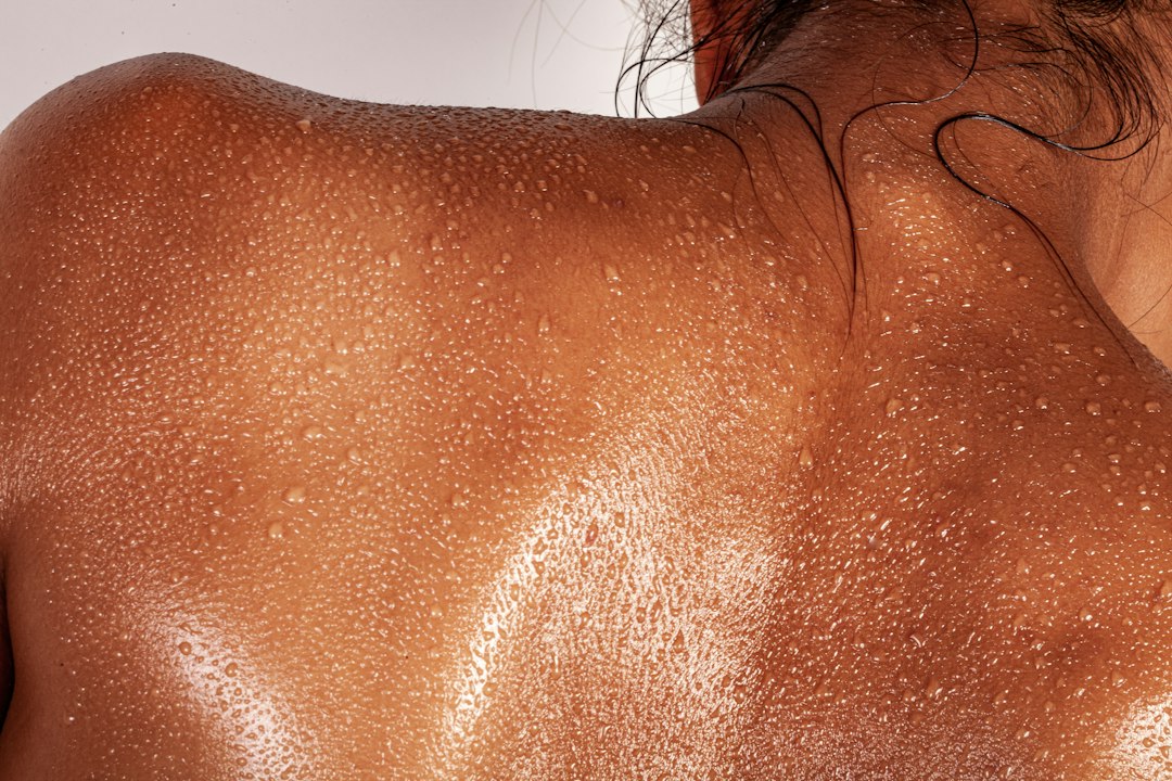 Sweat on a person's back and shoulders, a common trigger for shoulder acne